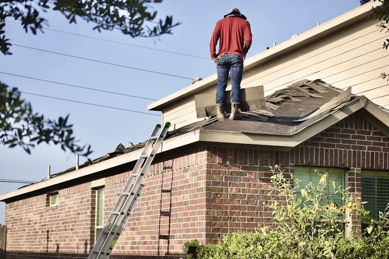Professional roofer working on a residential roof in Gaston